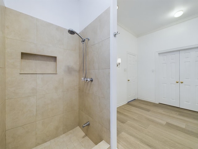5631 Winsome Ln, Houston, TX 77057 - bathroom featuring ornamental molding, a tile shower, and wood finished floors