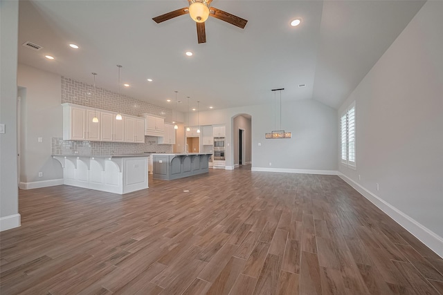 2206 Umber Oaks Ln, Brookshire, TX 77423 - unfurnished living room with a ceiling fan, arched walkways, wood finished floors, recessed lighting, and baseboards