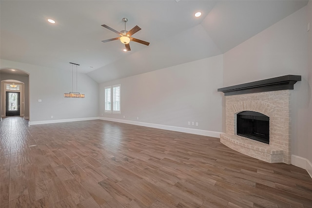 2206 Umber Oaks Ln, Brookshire, TX 77423 - unfurnished living room with vaulted ceiling, a ceiling fan, wood finished floors, baseboards, and a brick fireplace