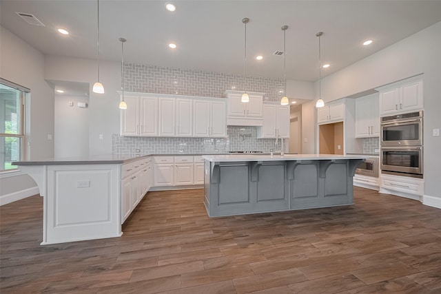 2206 Umber Oaks Ln, Brookshire, TX 77423 - kitchen with appliances with stainless steel finishes, backsplash, white cabinetry, dark wood finished floors, and recessed lighting