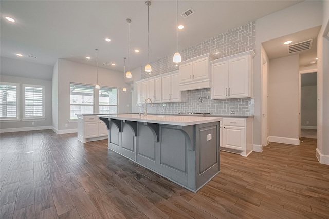2206 Umber Oaks Ln, Brookshire, TX 77423 - kitchen with a kitchen island with sink, baseboards, light countertops, dark wood-style floors, and recessed lighting