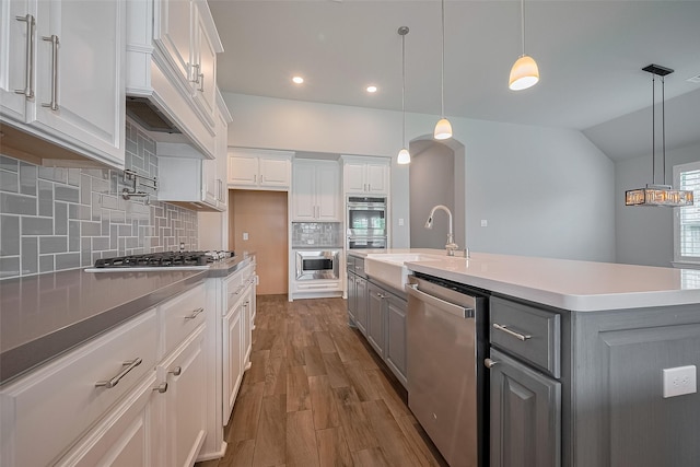 2206 Umber Oaks Ln, Brookshire, TX 77423 - kitchen with appliances with stainless steel finishes, a sink, gray cabinetry, white cabinets, and wood finished floors