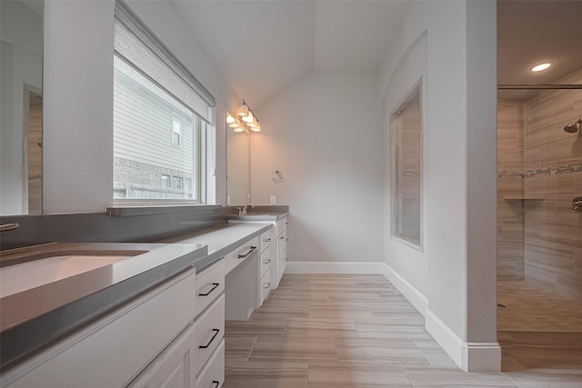 2206 Umber Oaks Ln, Brookshire, TX 77423 - bathroom featuring double vanity, lofted ceiling, tiled shower, baseboards, and recessed lighting