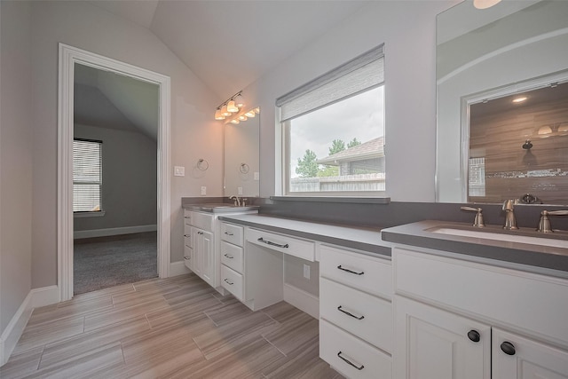 2206 Umber Oaks Ln, Brookshire, TX 77423 - bathroom with double vanity, lofted ceiling, wood finished floors, and baseboards