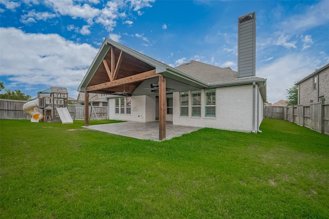 2206 Umber Oaks Ln, Brookshire, TX 77423 - back of house featuring a ceiling fan, a chimney, a patio, a playground, and a shingled roof