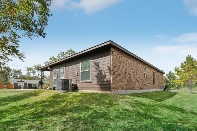 311 W Independence Dr, League City, TX 77573 - rear view of house with cooling unit, a yard, and brick siding