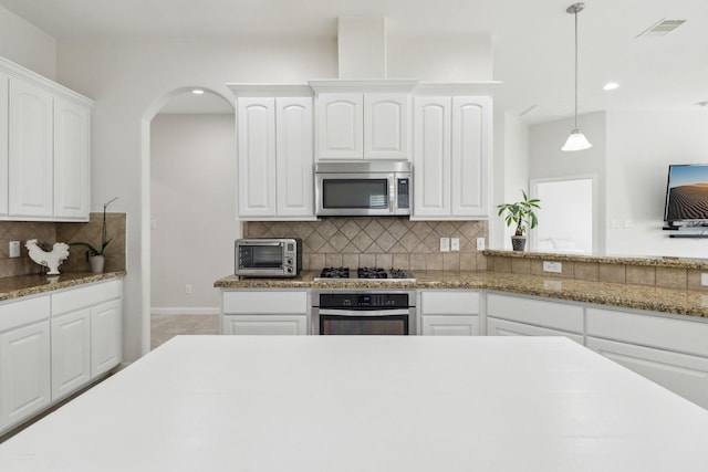 311 W Independence Dr, League City, TX 77573 - kitchen with stainless steel appliances, tasteful backsplash, recessed lighting, white cabinets, and decorative light fixtures