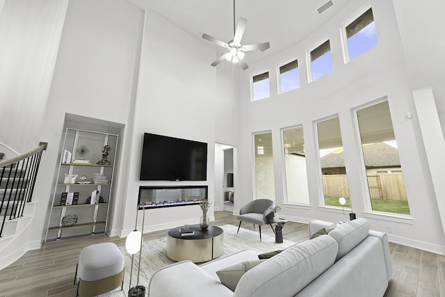 5041 Steady Breeze Dr, Katy, TX 77493 - living area featuring a towering ceiling, wood finished floors, a ceiling fan, and stairs