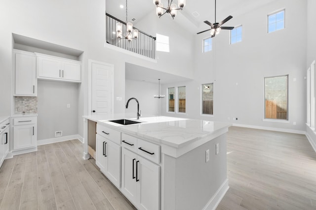 24727 Lobelia Garden Ln, Katy, TX 77493 - kitchen with a chandelier, a sink, a ceiling fan, light wood-type flooring, and a towering ceiling