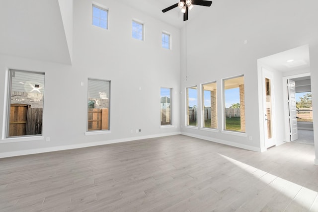 24727 Lobelia Garden Ln, Katy, TX 77493 - unfurnished living room with a ceiling fan, healthy amount of natural light, light wood-style flooring, and a high ceiling
