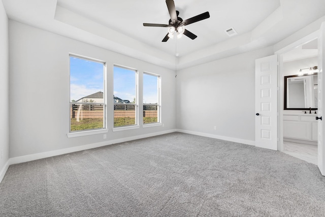 24727 Lobelia Garden Ln, Katy, TX 77493 - unfurnished bedroom featuring a raised ceiling, carpet floors, baseboards, and ensuite bath