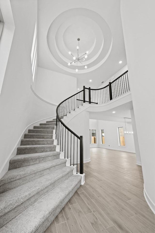 24718 Harrow Meadow Dr, Katy, TX 77493 - stairs featuring a chandelier, recessed lighting, a raised ceiling, baseboards, and a towering ceiling