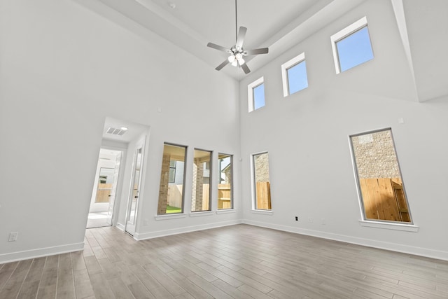 24718 Harrow Meadow Dr, Katy, TX 77493 - unfurnished living room with a towering ceiling, a ceiling fan, wood finished floors, and baseboards