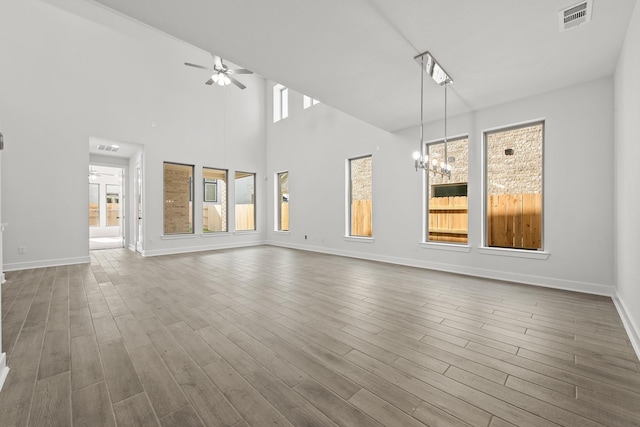 24718 Harrow Meadow Dr, Katy, TX 77493 - unfurnished living room with a ceiling fan, baseboards, dark wood finished floors, and a chandelier