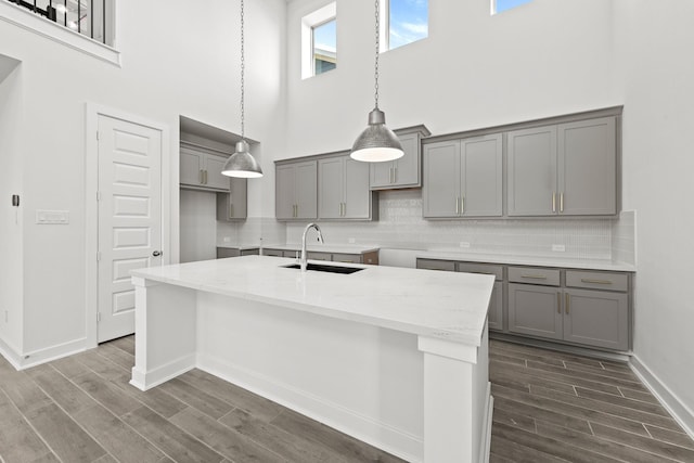 24718 Harrow Meadow Dr, Katy, TX 77493 - kitchen featuring gray cabinets, a sink, a towering ceiling, and dark wood-style floors