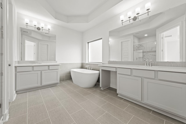 24718 Harrow Meadow Dr, Katy, TX 77493 - bathroom with a shower stall, tile walls, two vanities, a soaking tub, and wainscoting