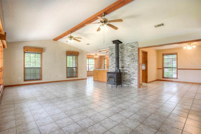 200 Cove View Dr, Trinity, TX 75862 - unfurnished living room with a wood stove, a ceiling fan, baseboards, a textured ceiling, and light tile patterned floors