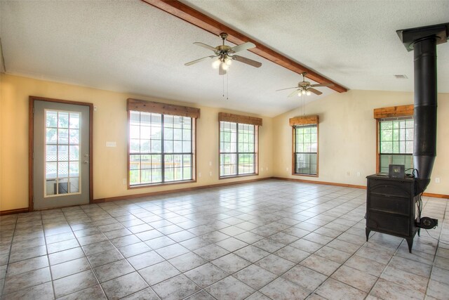 200 Cove View Dr, Trinity, TX 75862 - unfurnished living room featuring a wood stove, a textured ceiling, a ceiling fan, baseboards, and light tile patterned floors