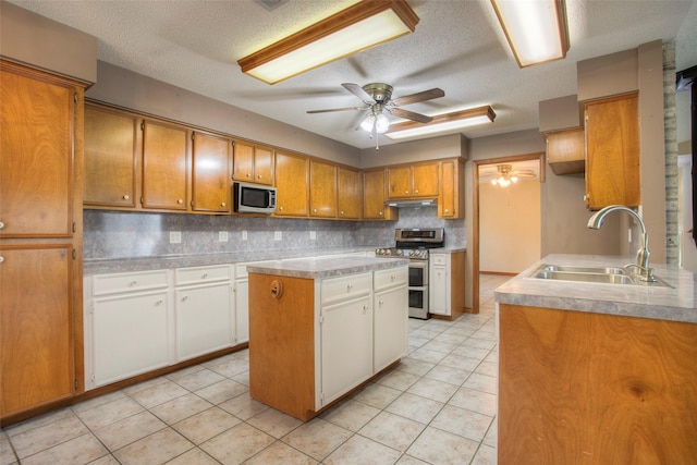 200 Cove View Dr, Trinity, TX 75862 - kitchen with stainless steel appliances, a sink, ceiling fan, decorative backsplash, and light countertops