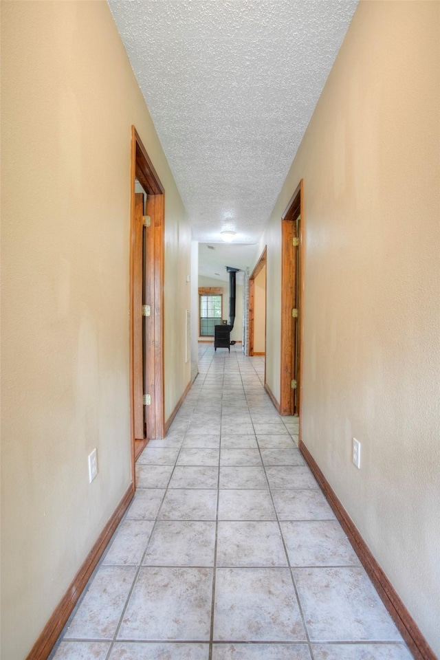 200 Cove View Dr, Trinity, TX 75862 - hall with a textured ceiling, baseboards, and light tile patterned floors