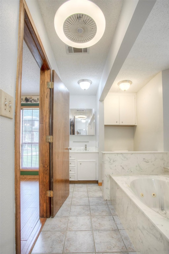 200 Cove View Dr, Trinity, TX 75862 - full bathroom with a textured ceiling, vanity, a jetted tub, and tile patterned floors