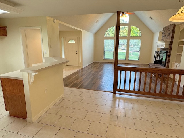 23315 Mystery St, Huffman, TX 77336 - unfurnished living room featuring ceiling fan, lofted ceiling, tile patterned flooring, a brick fireplace, and baseboards