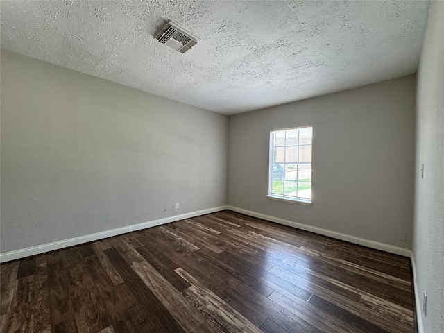 1206 Houston Ave, Pasadena, TX 77502 - empty room featuring baseboards, dark wood-style flooring, and a textured ceiling