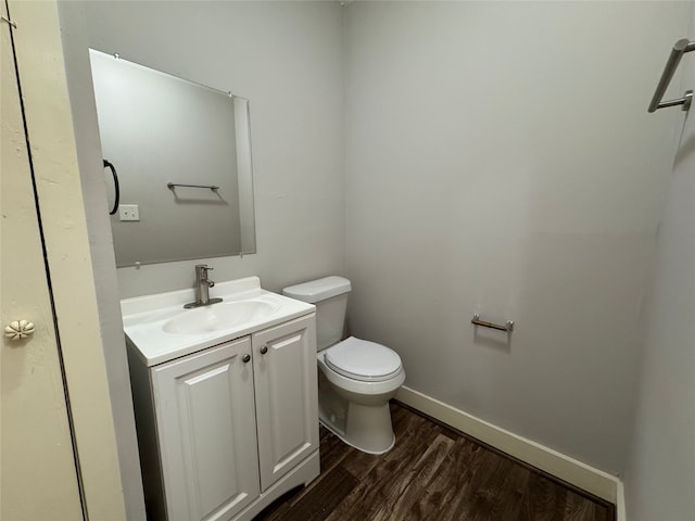 1206 Houston Ave, Pasadena, TX 77502 - bathroom with toilet, vanity, wood finished floors, and baseboards
