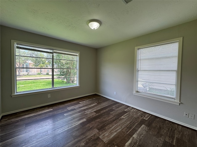 1206 Houston Ave, Pasadena, TX 77502 - unfurnished room with dark wood-type flooring, baseboards, and a textured ceiling