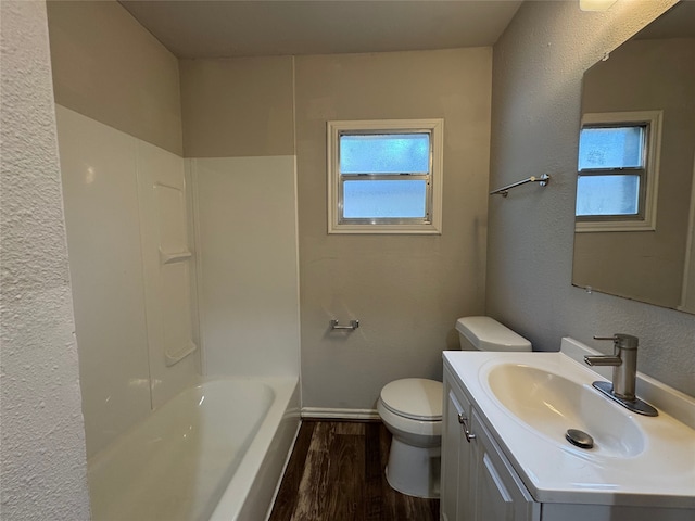 1206 Houston Ave, Pasadena, TX 77502 - bathroom with wood finished floors, toilet, vanity, a textured wall, and bathing tub / shower combination