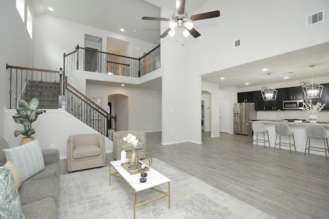 2221 Forest Chestnut Dr, Spring, TX 77386 - living area featuring arched walkways, a ceiling fan, stairway, recessed lighting, and a high ceiling