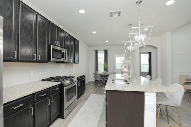 2221 Forest Chestnut Dr, Spring, TX 77386 - kitchen with stainless steel appliances, a breakfast bar, an island with sink, healthy amount of natural light, and recessed lighting
