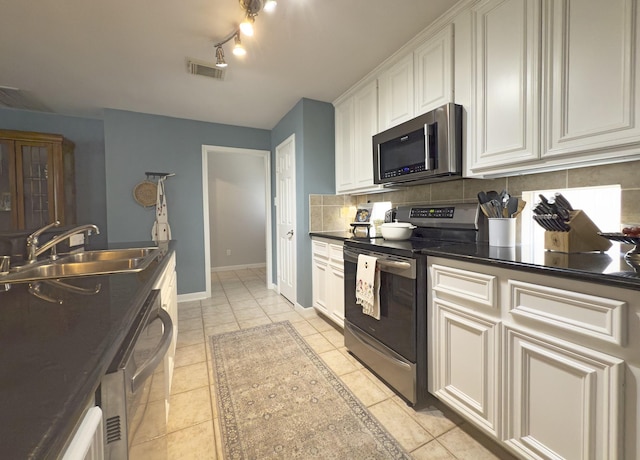 1919 Bailey St, Houston, TX 77006 - kitchen featuring stainless steel appliances, a sink, tasteful backsplash, dark countertops, and baseboards