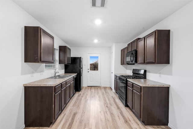 4331 Cedar Elm St, Baytown, TX 77521 - kitchen with black appliances, a sink, dark brown cabinetry, and light wood-style flooring