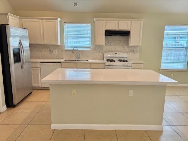 19119 Field Cottage Ln, Richmond, TX 77407 - kitchen with white appliances, a sink, exhaust hood, light tile patterned floors, and decorative backsplash