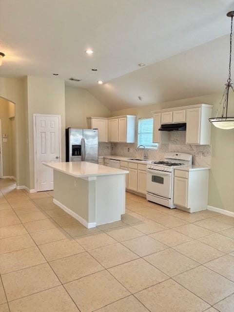 19119 Field Cottage Ln, Richmond, TX 77407 - kitchen with white appliances, a sink, lofted ceiling, under cabinet range hood, and light tile patterned floors