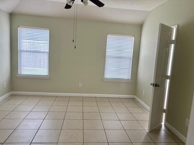 19119 Field Cottage Ln, Richmond, TX 77407 - empty room with ceiling fan, light tile patterned flooring, plenty of natural light, and baseboards