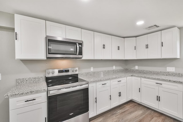 5419 Palmer St, Houston, TX 77004 - kitchen with stainless steel appliances, white cabinets, light wood-style flooring, and recessed lighting