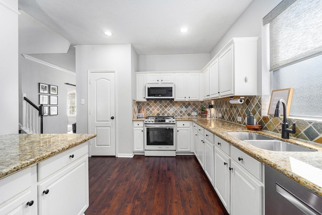 31215 Rainwood Park Ln, Spring, TX 77386 - kitchen with appliances with stainless steel finishes, a sink, decorative backsplash, dark wood-type flooring, and light stone counters
