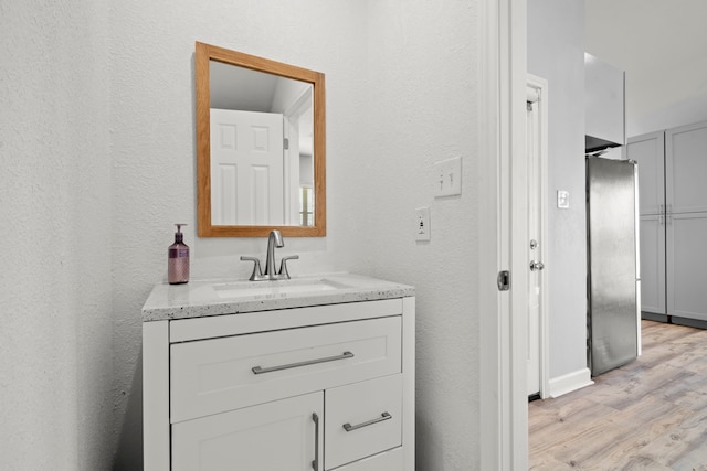 3582 County Road 476, Palacios, TX 77465 - bathroom featuring vanity, wood finished floors, and a textured wall