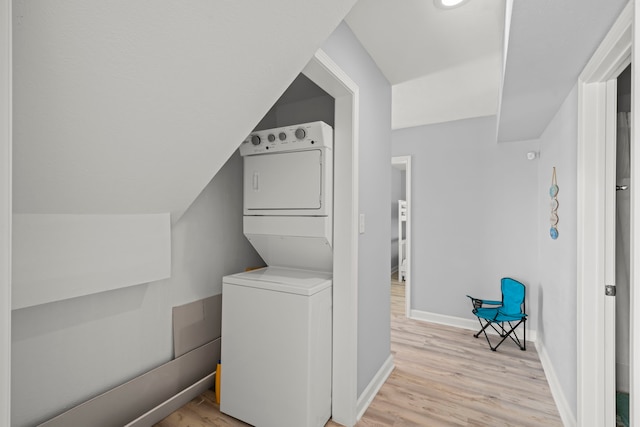 3582 County Road 476, Palacios, TX 77465 - laundry room featuring stacked washer / dryer, light wood-style floors, and baseboards