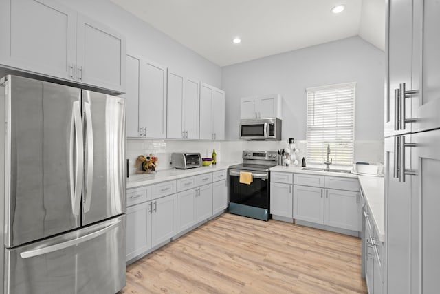 3582 County Road 476, Palacios, TX 77465 - kitchen with stainless steel appliances, a sink, tasteful backsplash, light countertops, and light wood-type flooring