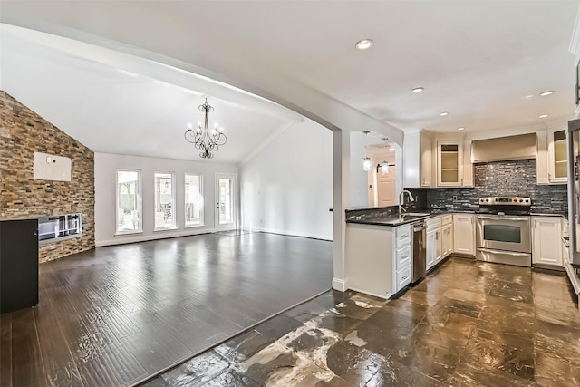 406 Westwood Dr, Friendswood, TX 77546 - kitchen featuring appliances with stainless steel finishes, vaulted ceiling, a chandelier, open floor plan, and glass insert cabinets