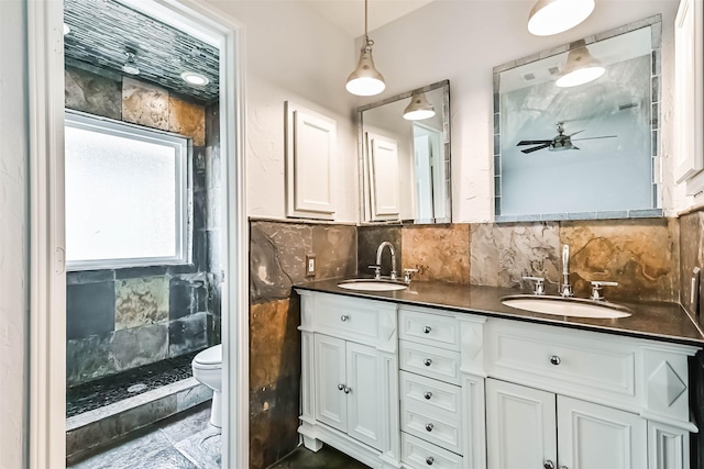 406 Westwood Dr, Friendswood, TX 77546 - bathroom featuring a ceiling fan, double vanity, toilet, and decorative backsplash