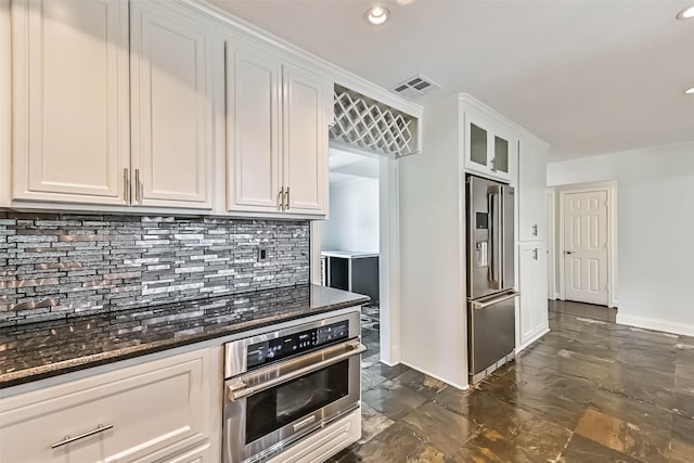 406 Westwood Dr, Friendswood, TX 77546 - kitchen with stainless steel appliances, backsplash, white cabinetry, dark stone countertops, and recessed lighting