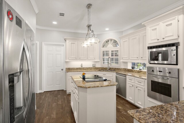 16022 Winchmore Hill Dr, Spring, TX 77379 - kitchen featuring appliances with stainless steel finishes, a sink, dark wood-style floors, a center island, and crown molding