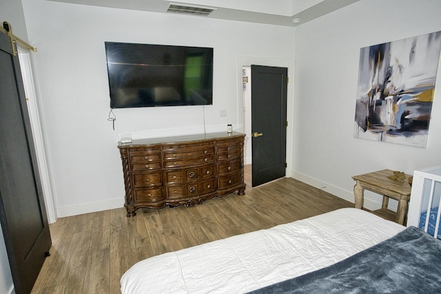 455 Green Meadows Dr, West Columbia, TX 77486 - bedroom with wood finished floors, baseboards, and a barn door