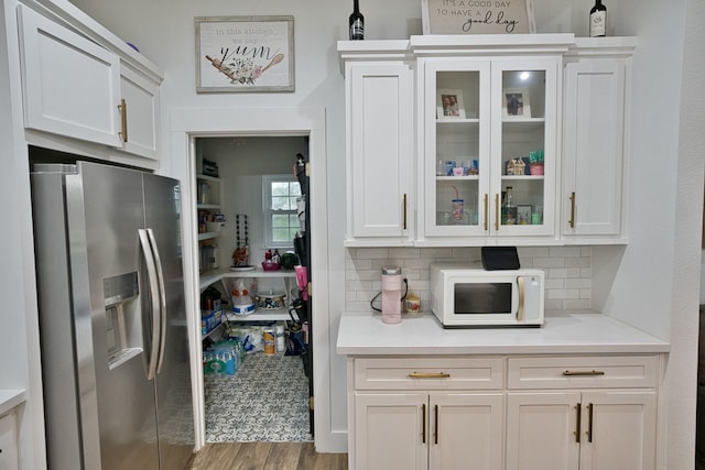 455 Green Meadows Dr, West Columbia, TX 77486 - kitchen with stainless steel refrigerator with ice dispenser, white microwave, white cabinets, and wood finished floors