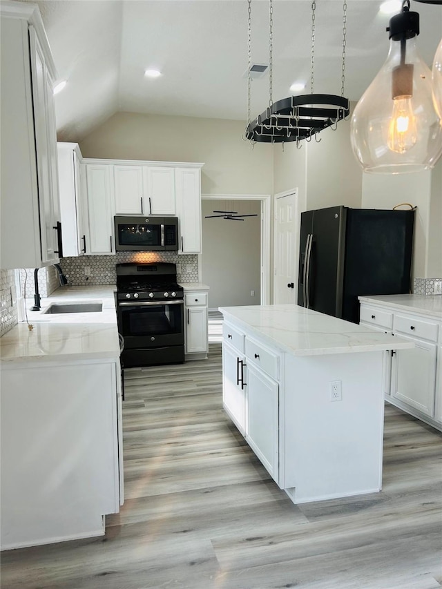 21227 River Knoll Ln, Katy, TX 77449 - kitchen featuring black appliances, a sink, tasteful backsplash, a kitchen island, and white cabinets