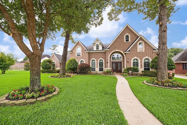 31415 Rigel Ct, Tomball, TX 77375 - colonial inspired home featuring brick siding, a front yard, and french doors